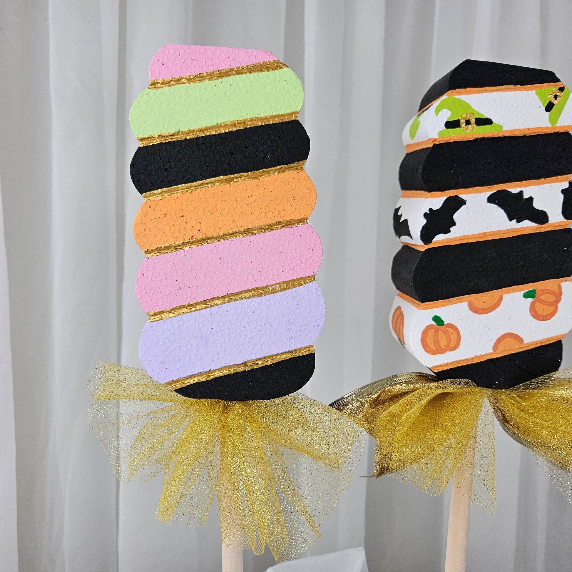 Close-up of handmade Halloween swirl stick pop with colorful witch hats, bats, and pumpkins